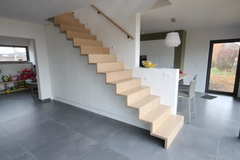 Escalier en Z avec mobilier intégré sous l'escalier. Marche en chêne verni, le reste peint en RAL 9010.